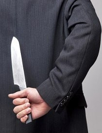 Businessman with a knife behind his back