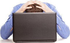 Man pounding head on computer